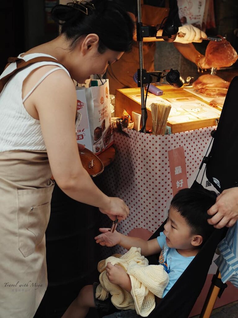 魷布院店員給排隊的小孩試吃
