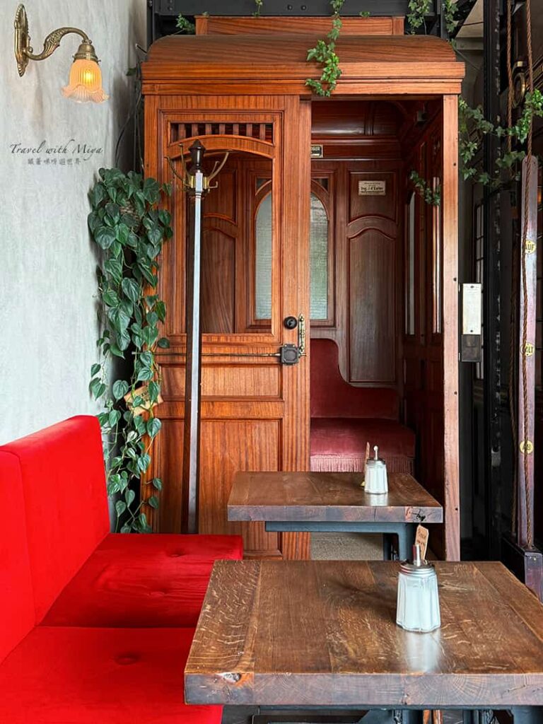維也納電梯咖啡廳 Aufzug Café 牆邊紅色沙發與壁燈和角落的電梯車廂