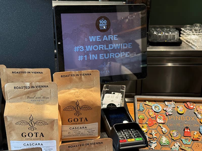Gota Coffee Experts 結帳區與螢幕上的字樣:世界第三、歐洲第一咖啡