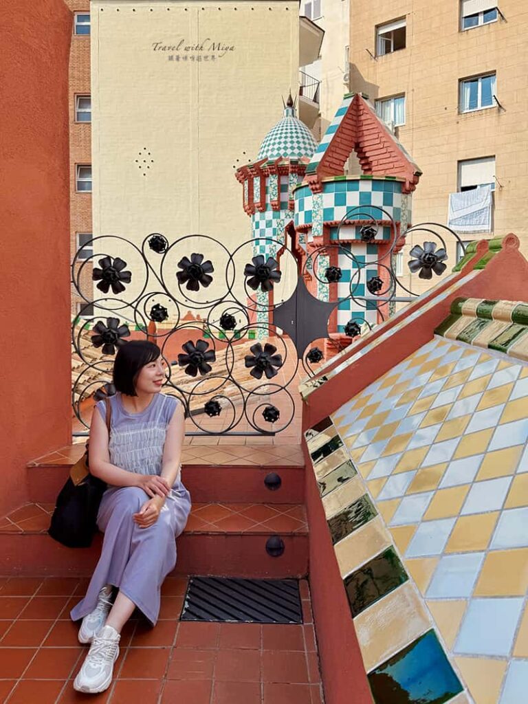 坐在巴塞隆納維森斯之家 Casa Vicens 屋頂周圍有繽紛磁磚與塔樓