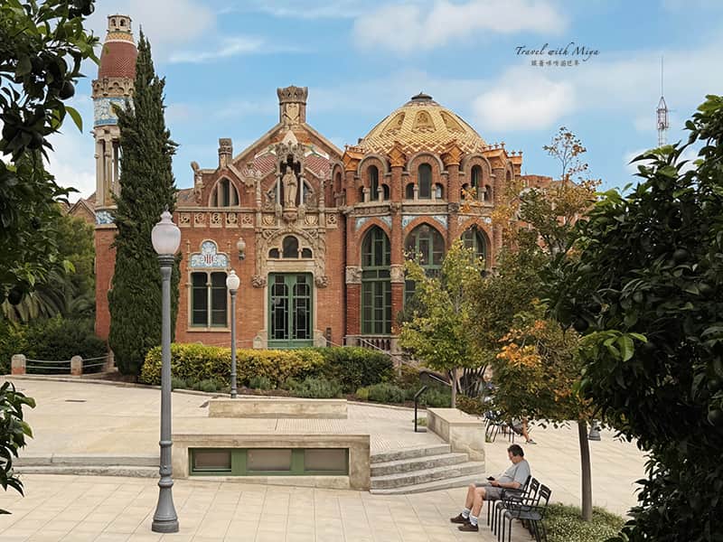 聖十字聖保羅醫院建築與樹下乘涼的男子