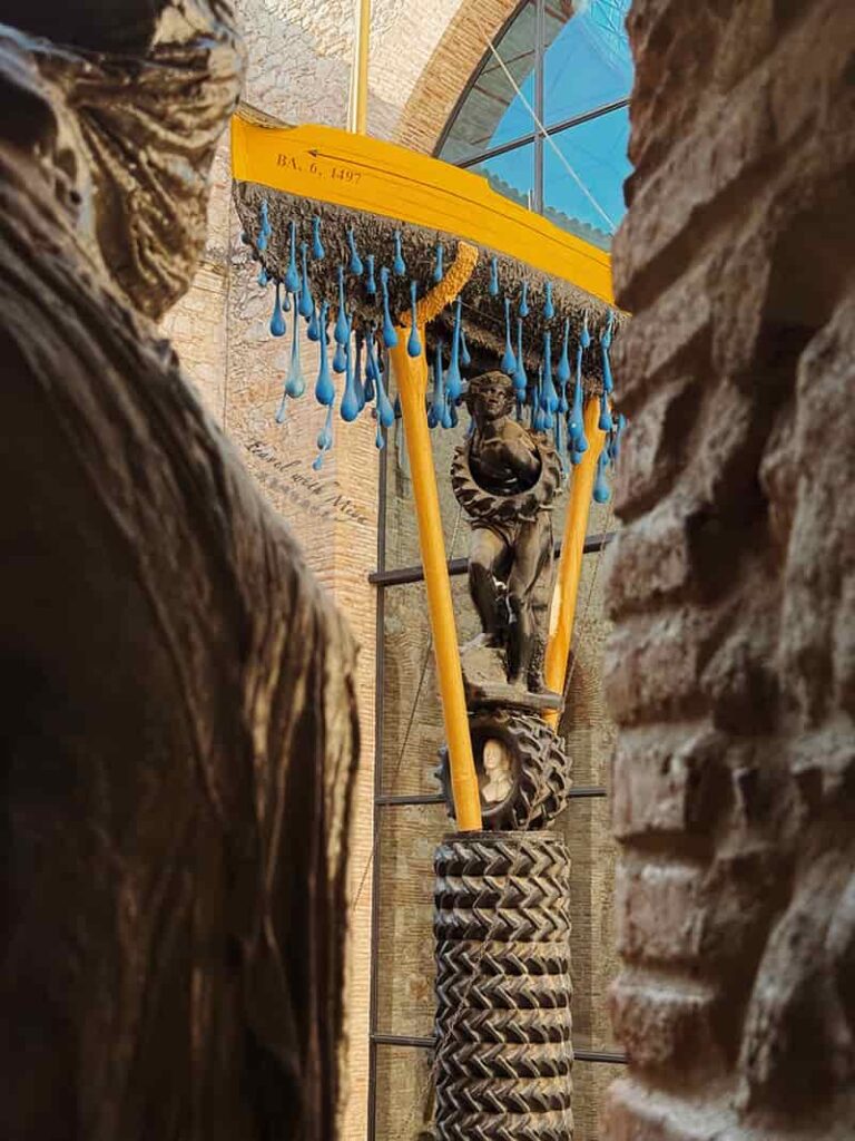 達利戲劇博物館中庭裝置:雨中計程車上方的黃色小船與輪胎柱